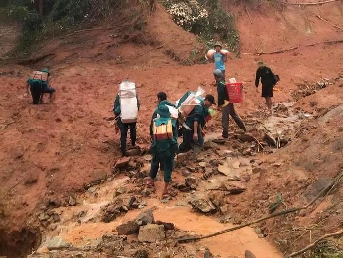 Đường bị chia cắt, bùn đất nhão, nhưng từng đoàn người vẫn kiên trì gùi gạo, mì tôm đến vùng bị cô lập ở thôn Sông Y (xã Trà Tân,Tp.Đà Nẵng).